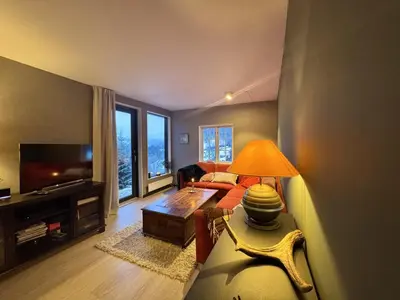a living room with a couch and a table with a lamp at Charming Cabin Near Hallingskarvet Ski Center, Cozy and Inviting! in Skoro