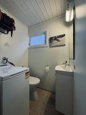 a white bathroom with a toilet and a sink at Charming Cabin Near Hallingskarvet Ski Center, Cozy and Inviting! in Skoro