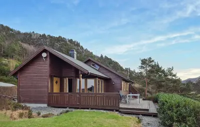 a small wooden house with a wooden deck at Gorgeous Home In Eivindvik With Wifi in Eivindvik