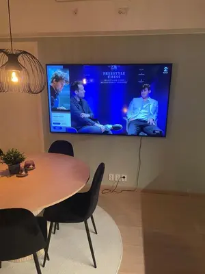 a room with a table and a tv on a wall at New Powerhouse apartment in Lade in Trondheim in Trondheim