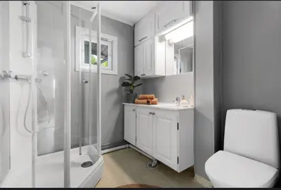 a white bathroom with a shower and a toilet at Cozy Apartment in Lillehammer in Lillehammer