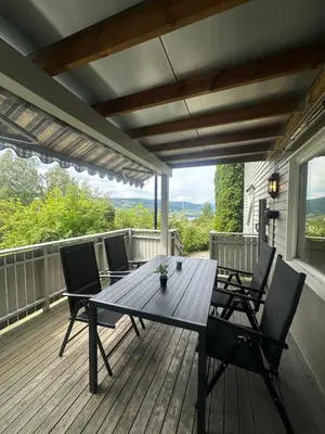 a wooden deck with a table and chairs on it at Cozy Apartment in Lillehammer in Lillehammer