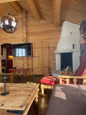 a living room with a fireplace in a log cabin at Kvenahytta in Markegardlian