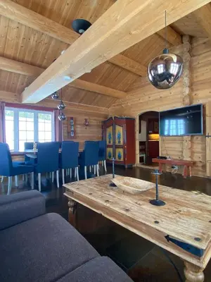 a living room with a wooden table and chairs at Kvenahytta in Markegardlian