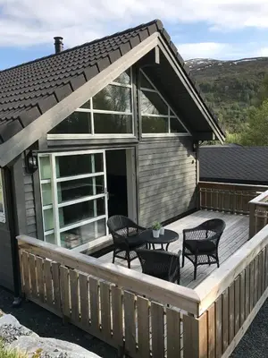 a deck with chairs and a table on a house at Amazing home in the heart of Nordfjordeid in Nordfjordeid