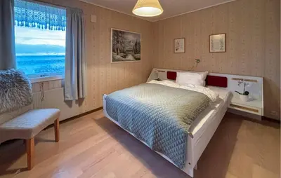 a bedroom with a bed and a window and a chair at 4 Bedroom Gorgeous Home In Atløy in Herland
