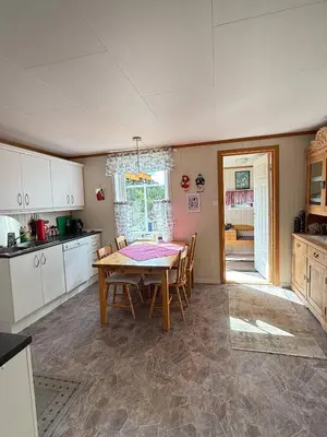 a kitchen with a table and chairs in a room at Kystperle med utsikt, lei en båt in Namsos