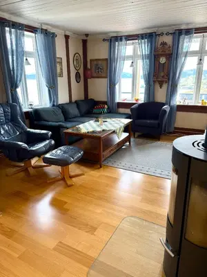 a living room with a couch and a table at Kystperle med utsikt, lei en båt in Namsos