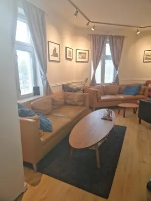 a living room with a couch and a table at Sentrumsnær stor leilighet in Trondheim
