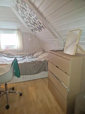 a bedroom with a bed and a desk and a chair at Sentrumsnær stor leilighet in Trondheim