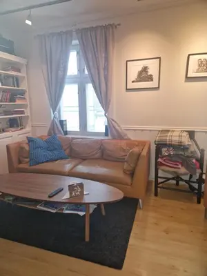 a living room with a couch and a table at Sentrumsnær stor leilighet in Trondheim