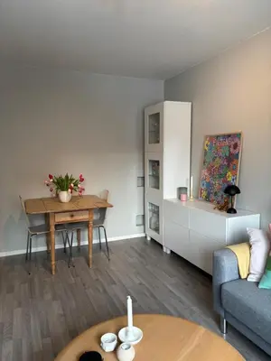 a living room with a table and a couch at 1-bedroom apartment in Trondheim