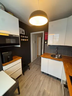 a kitchen with white cabinets and a sink at 1-bedroom apartment in Trondheim