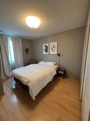 a bedroom with a large bed with a white comforter at 1-bedroom apartment in Trondheim