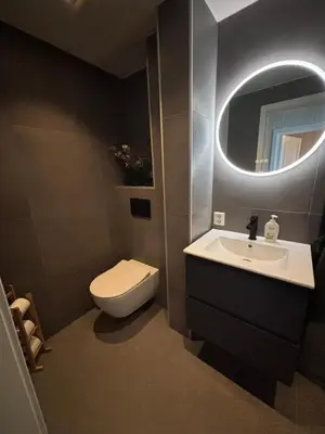 a bathroom with a toilet and a sink and a mirror at 1-bedroom apartment in Trondheim