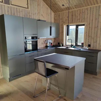 a kitchen with a table and a chair in it at Skogbrynet hytte in Svingvoll