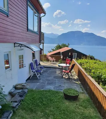 a patio with chairs and a table next to a house at Hardangerfjord panorama 2 in Kvam