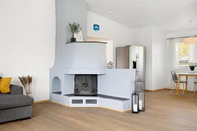 a living room with a fireplace in the middle at World Cup Trondheim 2025 in Trondheim