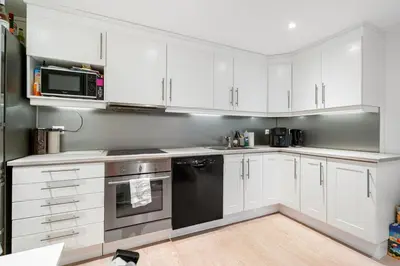 a kitchen with white cabinets and a black appliance at World Cup Trondheim 2025 in Trondheim