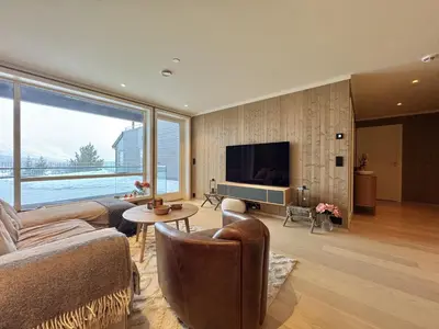 a living room with a couch and a tv at Exclusive and cozy apartment central Geilo area in Geilo