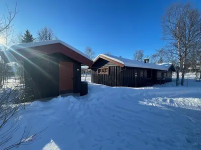 a building covered in snow with the sun shining on it at Charming Mountain Retreat Near Ski Trails And Beitostølen Center in Beitostøl