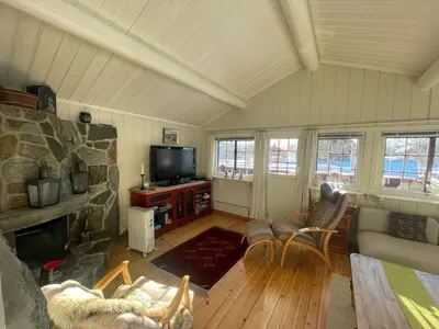 a living room with a stone fireplace and a tv at Charming Mountain Retreat Near Ski Trails And Beitostølen Center in Beitostøl