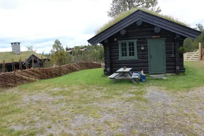 a small cabin with a picnic table in front of it at Koselig hytte Gålå Vakre Lauvåsen in Sør-Fron