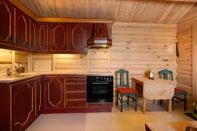 a kitchen with wooden cabinets and a table with chairs at Koselig hytte Gålå Vakre Lauvåsen in Sør-Fron