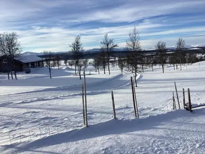 a fence in a snow covered field with trees at Koselig hytte Gålå Vakre Lauvåsen in Sør-Fron