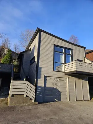 a small house with a large window and a garage at Guesthouse-Ølen, 2 bedroom in Dørheim