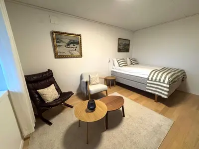 a bedroom with a bed and a chair and a table at Appartment with garden in Malvik