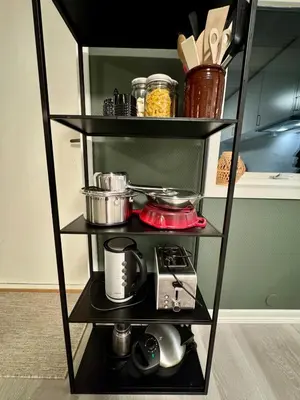 a black shelf with pots and pans on it at Appartment with garden in Malvik