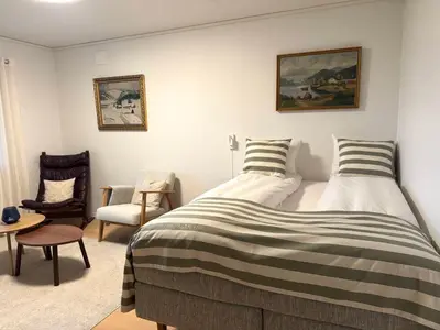 a bedroom with a bed and a chair at Appartment with garden in Malvik
