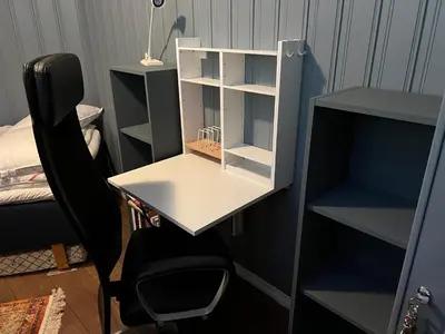a desk with a chair next to a book shelf at Skiidyll Med Utsikt Og Peis in Beitostøl