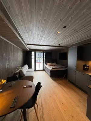 a living room with a bed and a table at New! Apartment Fjellandsbyen Hemsedal Ski&bike in Kyrkjebøen