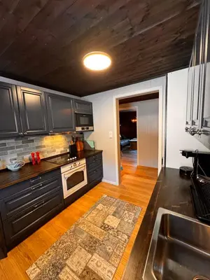 a kitchen with black cabinets and a wooden floor at Ustedalen Lodge in Geilo