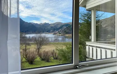 a window with a view of a lake and mountains at Gorgeous Home In Åheim in Åheim