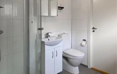 a bathroom with a toilet and a sink and a shower at Gorgeous Home In Åheim in Åheim