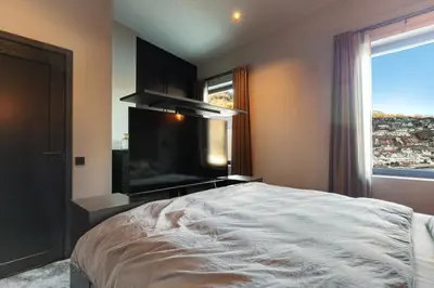 a bedroom with a large bed and a large window at Penthouse with fjord view and parking in Sogndal