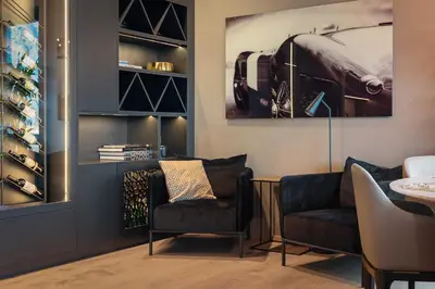a living room with two chairs and a painting on the wall at Penthouse with fjord view and parking in Sogndal