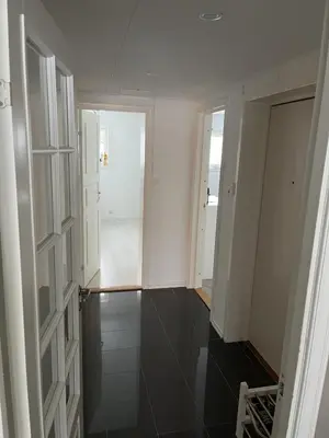 a room with white walls and a hallway with black tiles at Trondheim in Trondheim