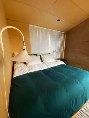 a bedroom with a large green bed with a lamp at Luxury private house with Amazing view! in Trondheim