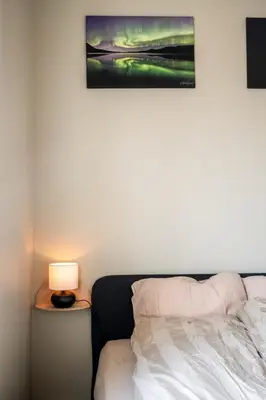 a bedroom with a bed and a lamp on a table at 3F - In the heart of Trondheim in Trondheim