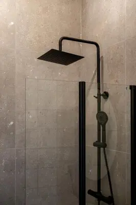 a shower with a glass door with a shower head at 3F - In the heart of Trondheim in Trondheim