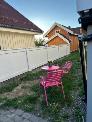 a pink table and two chairs in a yard at Bright and nice downtown apartment in Lillehammer