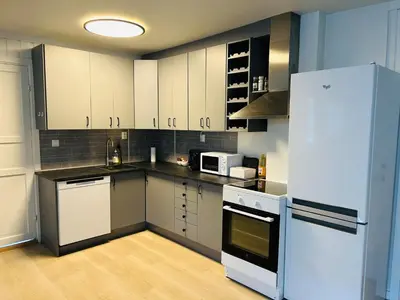a kitchen with white cabinets and a white refrigerator at Central apartment - Free parking and Wi-Fi in Lillehammer
