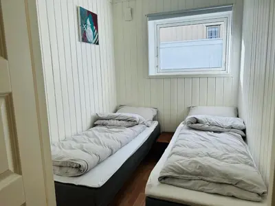 two beds in a room with a window at Central apartment - Free parking and Wi-Fi in Lillehammer