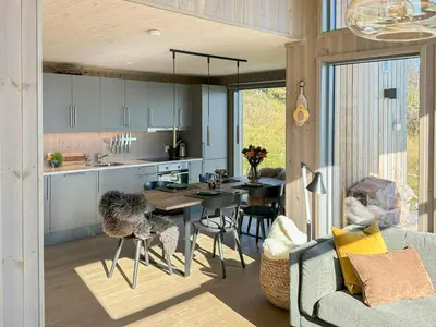 a kitchen and living room with a table and chairs at Architect Designed Cabin With Panoramic Views in Ål
