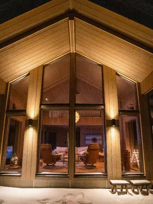 a house with large glass windows and a table and chairs at Modern Cabin In Scenic Valdres Nature Park in Ron