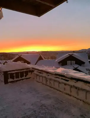 a view of snow covered roofs with the sunset in the background at Cabin With Ski Inski Out In Rauland in Rauland